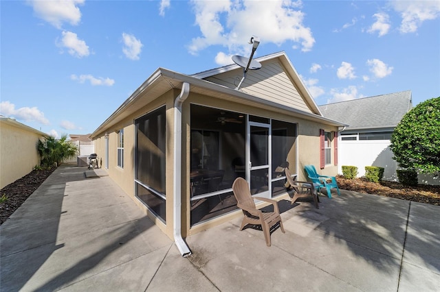 rear view of property featuring a sunroom and a patio