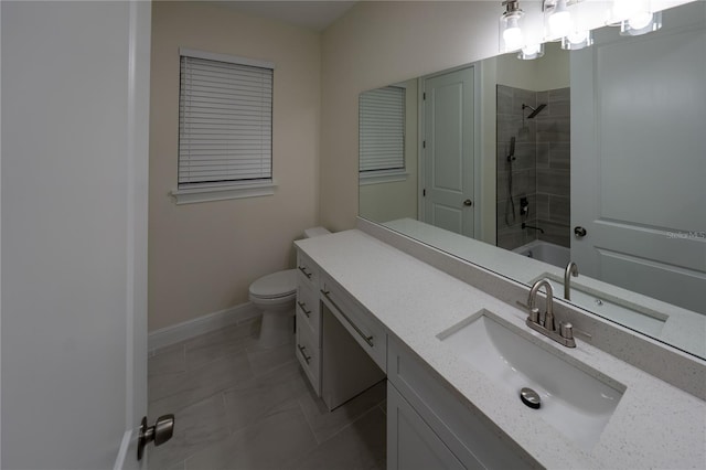 full bathroom with toilet, tiled shower / bath, tile patterned floors, and vanity