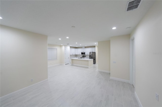 unfurnished living room featuring sink