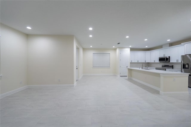 kitchen with white cabinets, sink, an island with sink, and stainless steel appliances