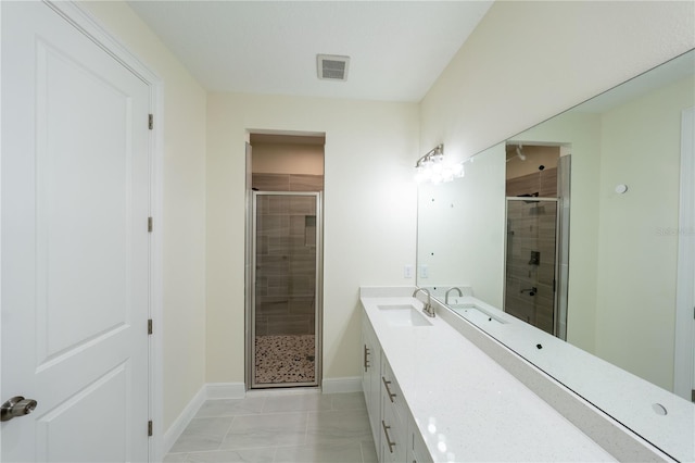 bathroom with an enclosed shower, vanity, and tile patterned flooring