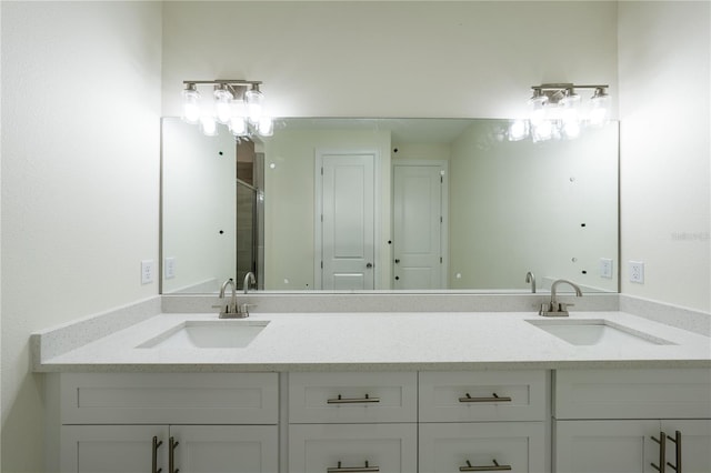 bathroom featuring a shower with shower door and vanity