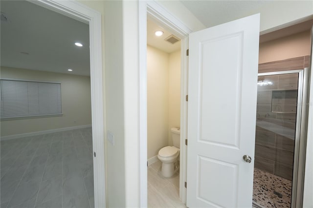 bathroom featuring toilet, tile patterned flooring, and walk in shower