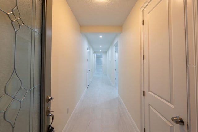 hallway with a textured ceiling