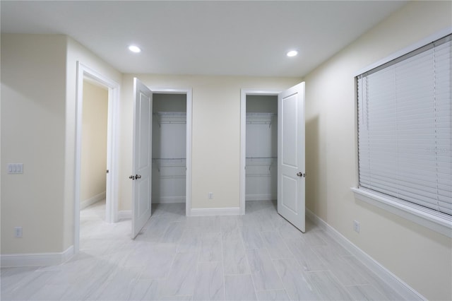 unfurnished bedroom featuring multiple closets