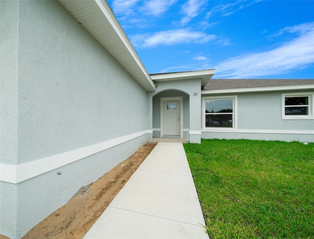 view of exterior entry featuring a yard