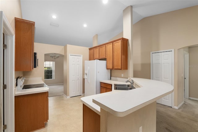 3107 NE 24th Pl, Ocala, FL 34470 - kitchen with white appliances, a peninsula, light countertops, brown cabinets, and a sink
