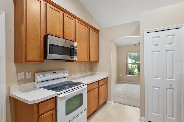 3107 NE 24th Pl, Ocala, FL 34470 - kitchen featuring stainless steel microwave, white electric range, arched walkways, light countertops, and lofted ceiling