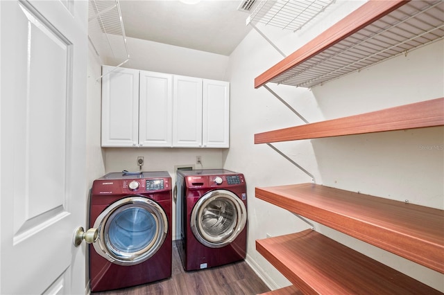 laundry room with cabinets, washer and clothes dryer, and dark wood-type flooring