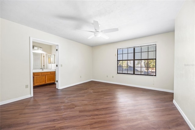 empty room featuring dark hardwood / wood-style floors, ceiling fan, and sink