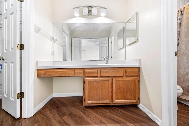 bathroom with hardwood / wood-style floors, vanity, and toilet