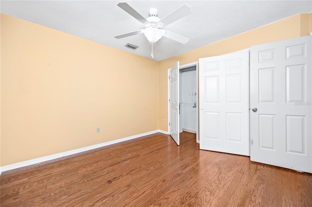 unfurnished bedroom featuring hardwood / wood-style flooring, a closet, and ceiling fan