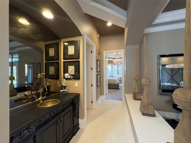 bathroom with crown molding, vanity, and a chandelier