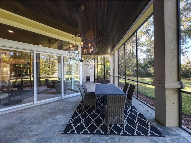 sunroom featuring a notable chandelier, a healthy amount of sunlight, and wood ceiling