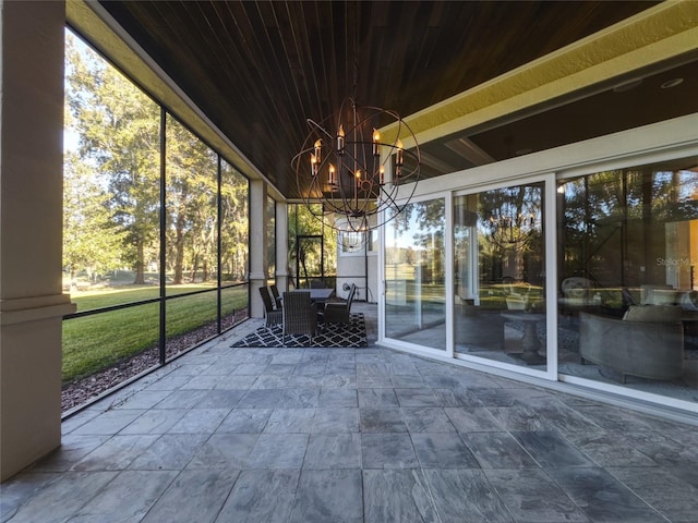 unfurnished sunroom with wooden ceiling, a wealth of natural light, and a chandelier