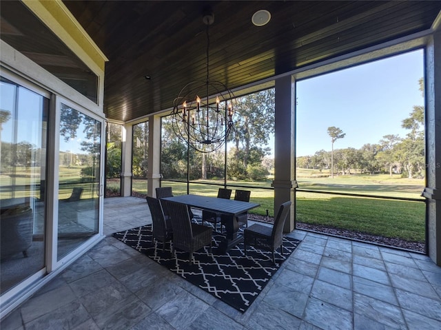 sunroom / solarium with a wealth of natural light, wood ceiling, and an inviting chandelier