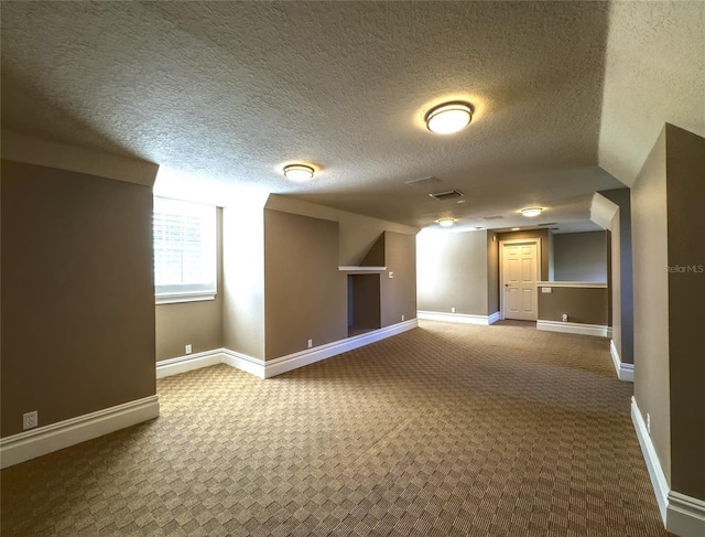 additional living space with carpet and a textured ceiling