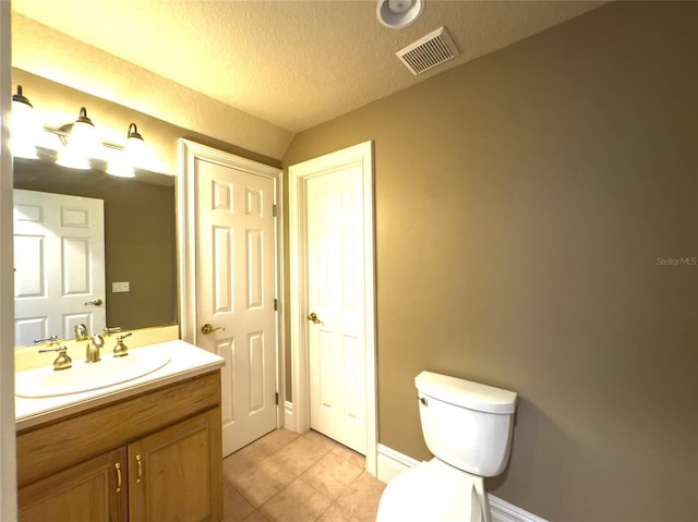 bathroom featuring tile patterned flooring, vanity, toilet, and a textured ceiling