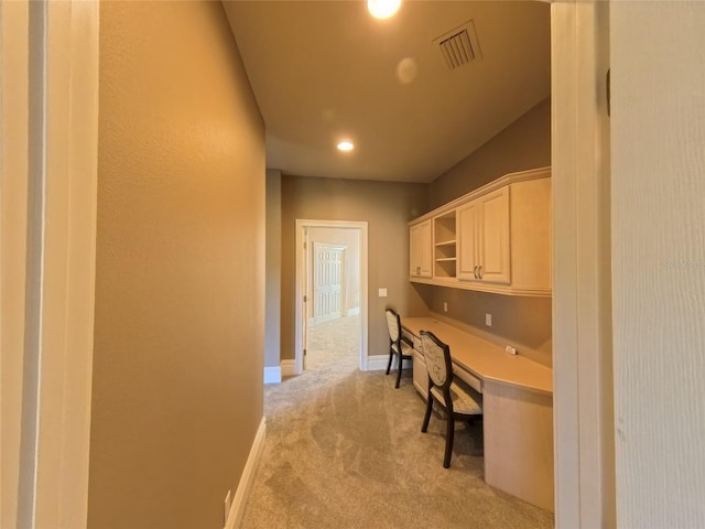 carpeted home office with built in desk