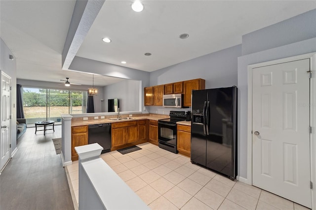 kitchen with black appliances, sink, ceiling fan, decorative light fixtures, and kitchen peninsula