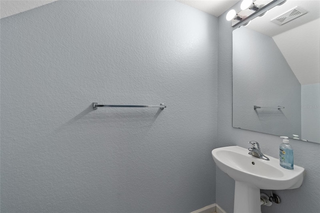 bathroom featuring sink and vaulted ceiling