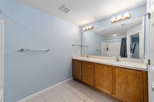 bathroom with tile patterned floors, vanity, a shower with curtain, and a textured ceiling