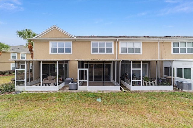 rear view of house with a sunroom, cooling unit, and a yard