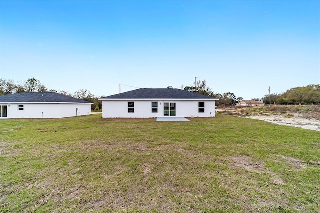 rear view of house with a lawn and a patio area