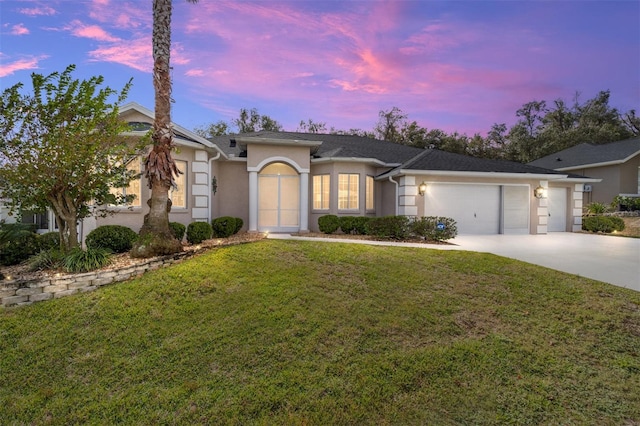 view of front of house featuring a garage and a yard