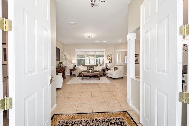 living room featuring light tile patterned floors and ornate columns