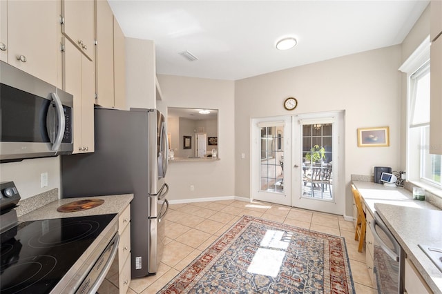 kitchen with french doors, light tile patterned flooring, and stainless steel appliances