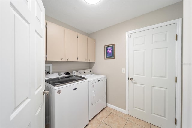 laundry room featuring cabinets, light tile patterned floors, and independent washer and dryer