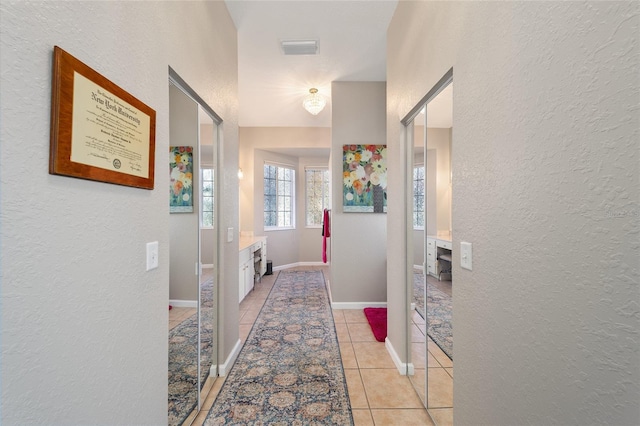 hall featuring light tile patterned floors