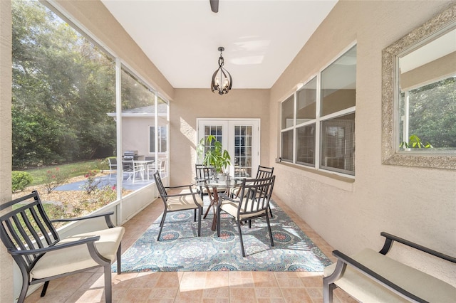 sunroom featuring a chandelier and french doors