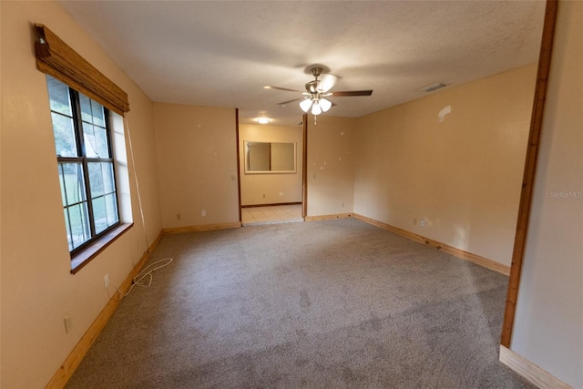 empty room with light carpet, a textured ceiling, and ceiling fan