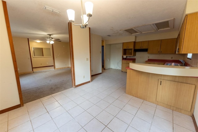 kitchen featuring hanging light fixtures, kitchen peninsula, a textured ceiling, light tile patterned flooring, and ceiling fan with notable chandelier