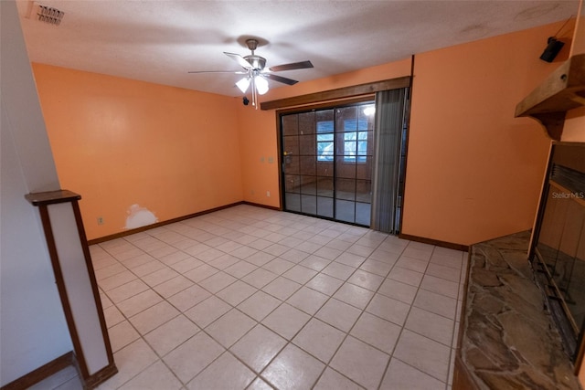 tiled spare room with ceiling fan and a textured ceiling