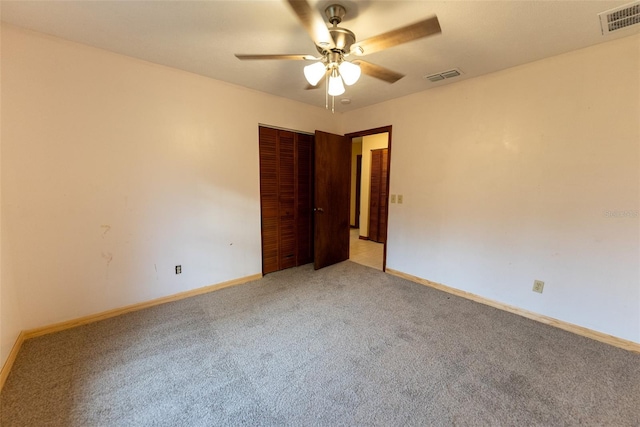 empty room featuring ceiling fan and carpet