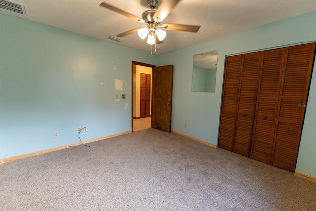 unfurnished bedroom featuring ceiling fan, a closet, and light carpet