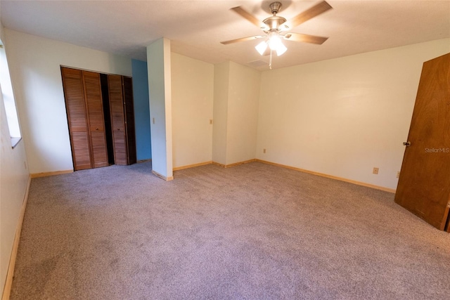 unfurnished bedroom with ceiling fan, a closet, and light colored carpet