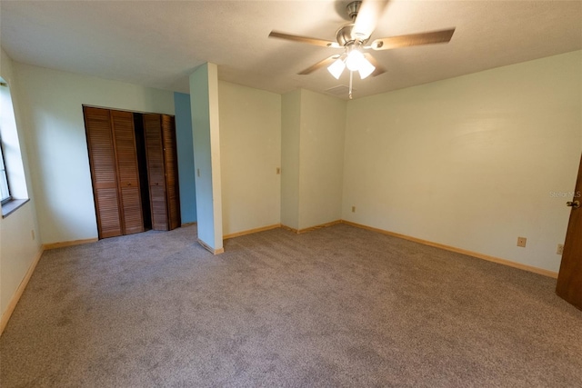 carpeted spare room featuring ceiling fan