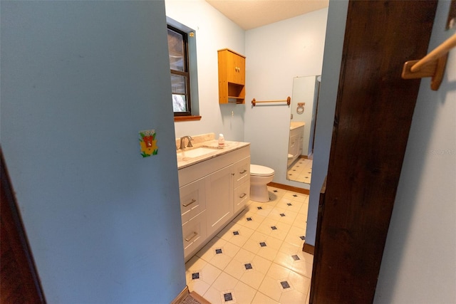 bathroom featuring tile patterned flooring, vanity, and toilet