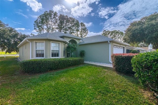 ranch-style home with a front lawn and a garage