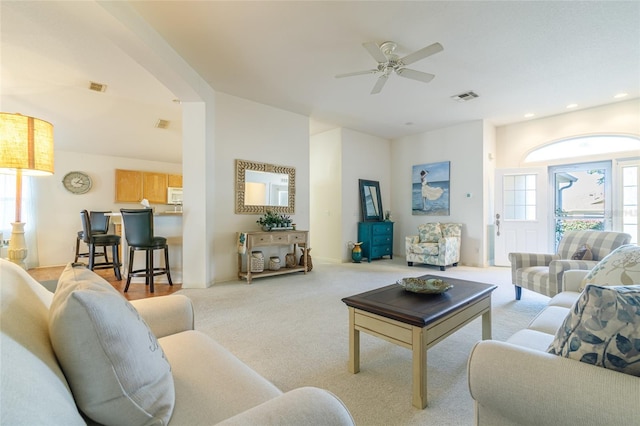 carpeted living room with ceiling fan and a healthy amount of sunlight