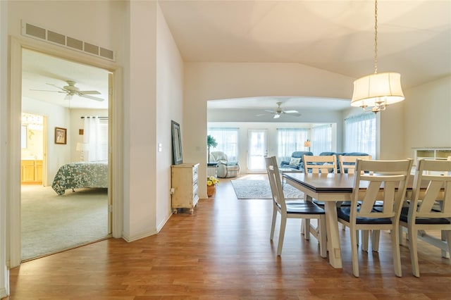 dining space with hardwood / wood-style flooring, ceiling fan, and vaulted ceiling