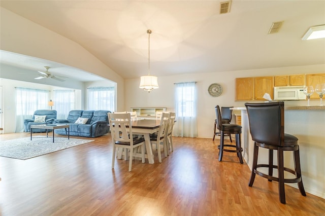 dining space with vaulted ceiling, light hardwood / wood-style flooring, plenty of natural light, and ceiling fan