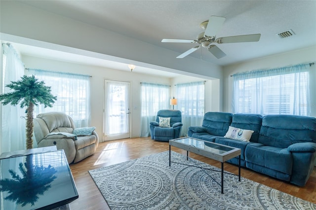 living room with wood-type flooring, a textured ceiling, and ceiling fan