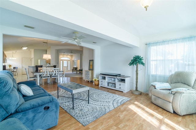 living room featuring ceiling fan, wood-type flooring, and vaulted ceiling