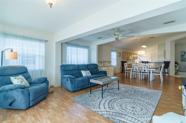 living room featuring ceiling fan, vaulted ceiling, and light hardwood / wood-style flooring