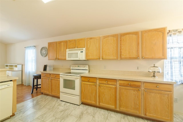 kitchen with light hardwood / wood-style flooring, a healthy amount of sunlight, white appliances, and light brown cabinets